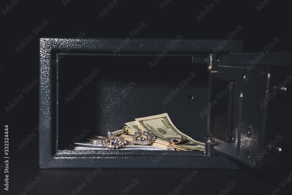 Safe box with valuables on dark background