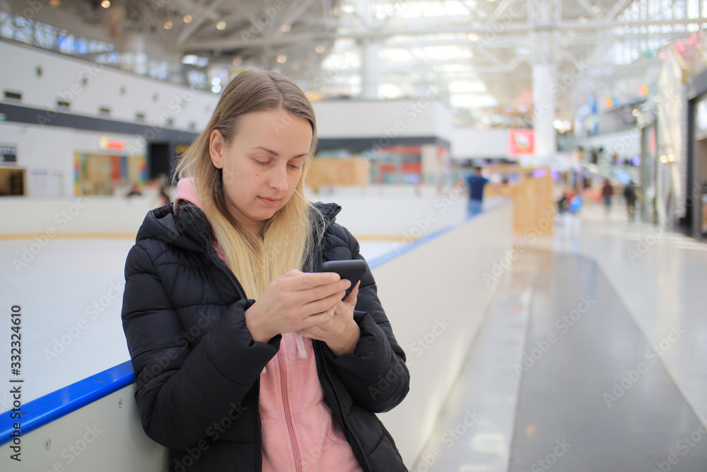 Sad woman customer in empty shopping mall with smartphone doing order online Sad woman customer in empty shopping mall with smartphone doing order online