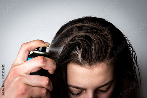 Fényképezés Woman applying dry spray shampoo on her dirty hair