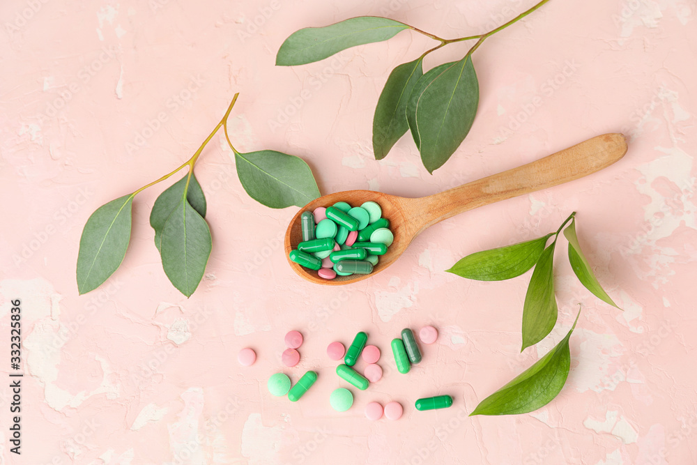 Spoon with plant based pills on color background Spoon with plant based pills on color background