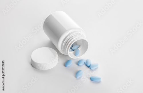 Bottle with sex pills on white background