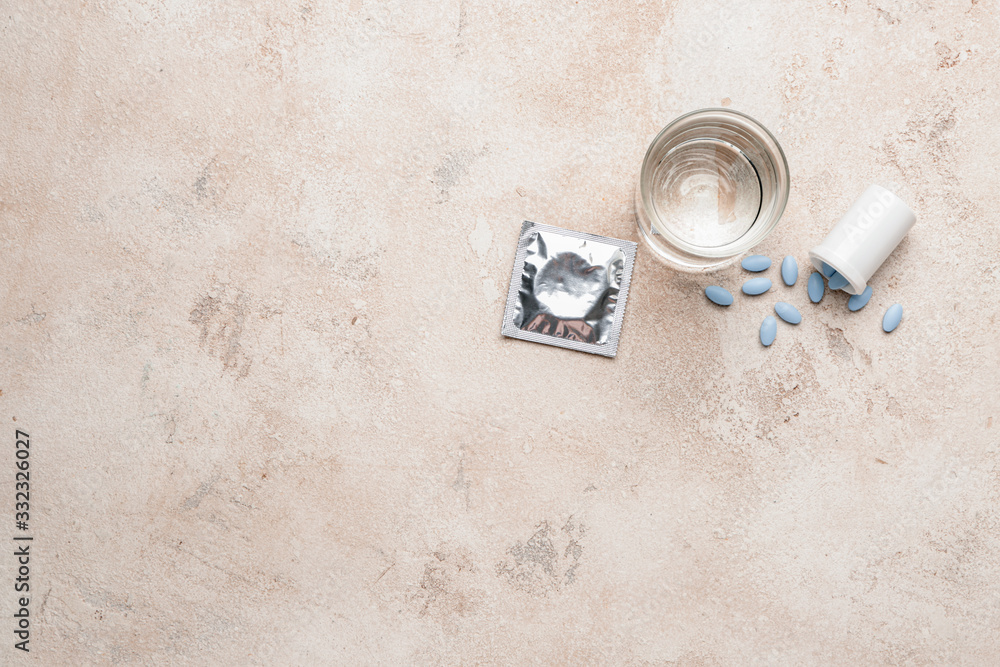 Bottle with sex pills, glass of water and condom on white background Bottle with sex pills, glass of water and condom on white background