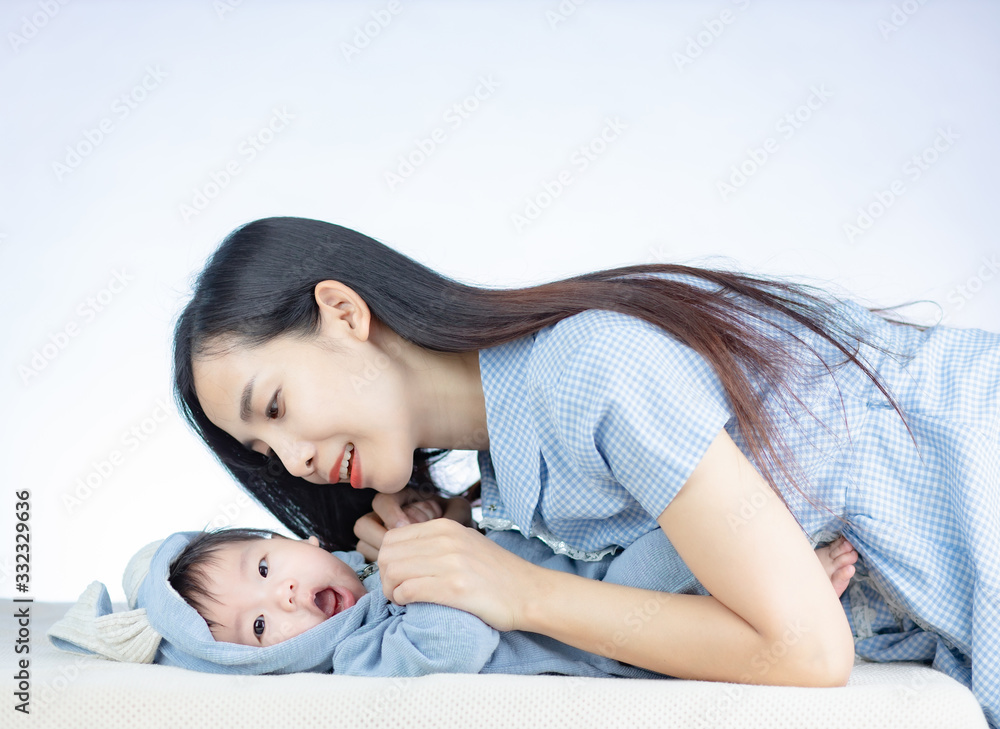 Εκτύπωση καμβά Beautiful young mom staring at her cute little baby in blue bunny costume