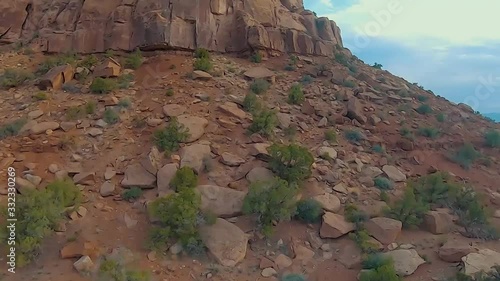 Cinematic FPV racing drone performs aerial flips and stunts in a desert canyon photo