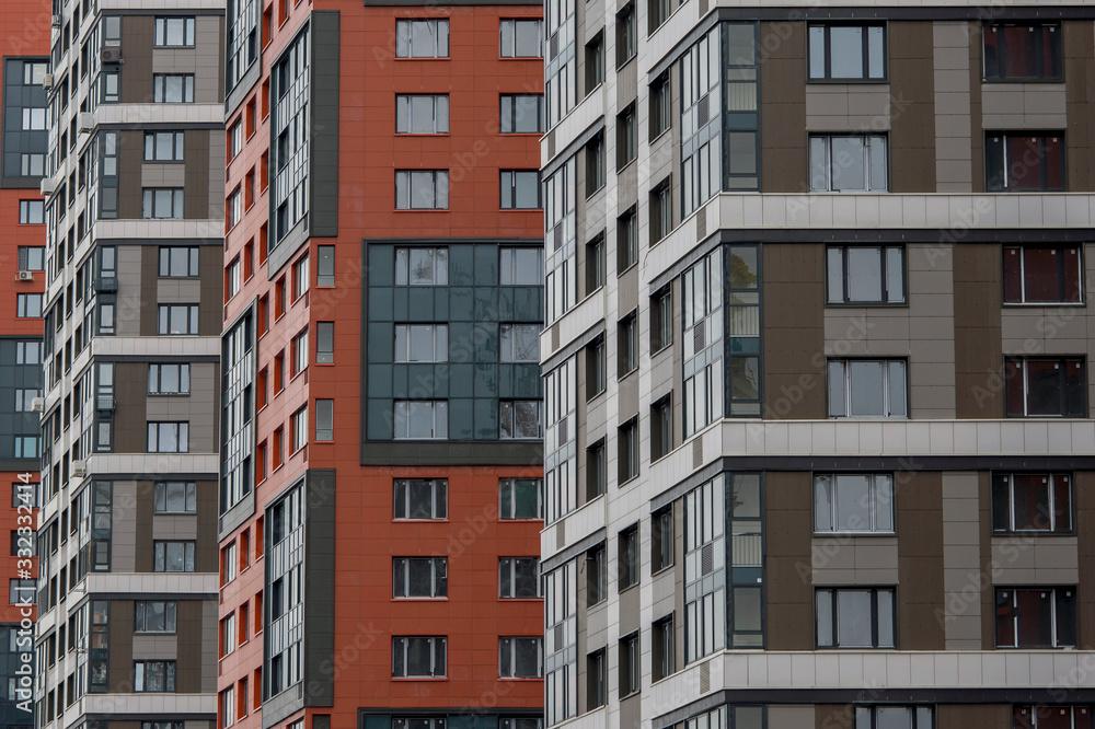 A row of modern colored multi-story buildings with close -up Windows. Background