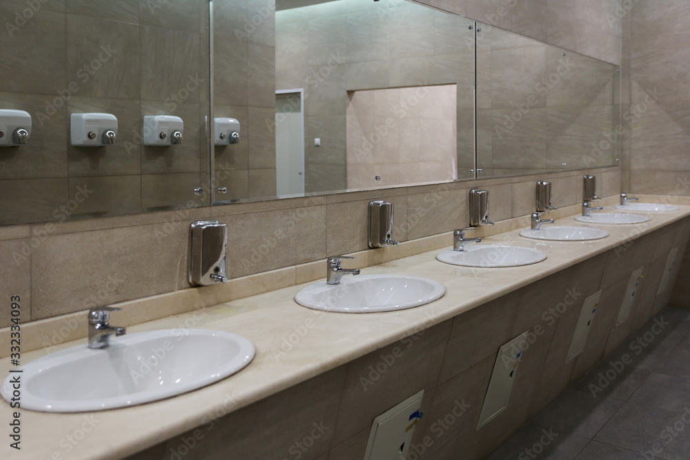 Fototapeta premium sinks in a row in a public toilet