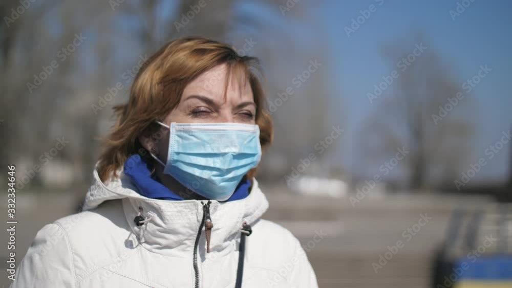 Confident blonde woman in a sanitary mask standing on Dnipro quay in spring Confident blonde woman in a sanitary mask standing on Dnipro quay in spring