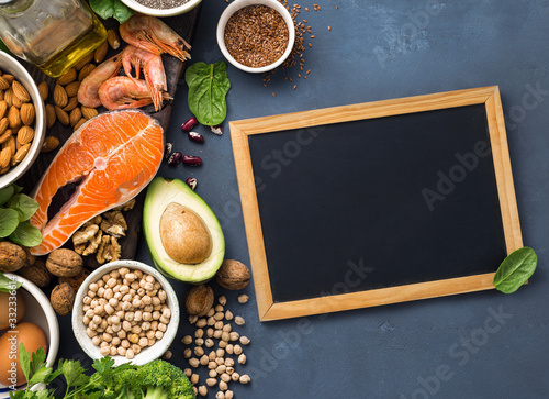 Empty chalkboard for your text with Food sources of omega 3 and healthy fats. Foods high in fatty acids including vegetables, seafood, nut and seeds