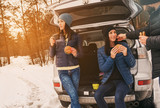 Group friends winter wear snowy winter forest talk drinking coffee car