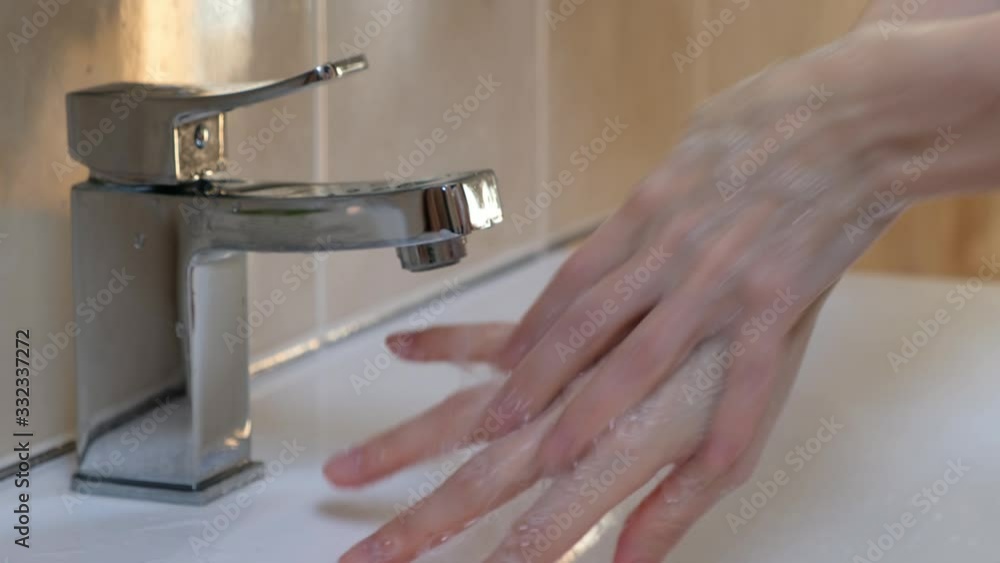Woman washing hands at the wash basin with foam, cleanse the skin from viruses. Pandemia of corona virus Woman washing hands at the wash basin with foam, cleanse the skin from viruses. Pandemia of corona virus