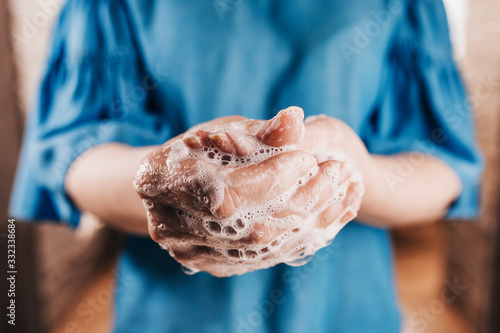 Fotografi Coronovirus spread prevention - Caucasian woman washes her hands thoroughly with