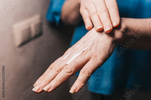 Fototapeta Naklejka Na Ścianę i Meble -  Hand moisturizing mask - apply a thick layer of hand cream