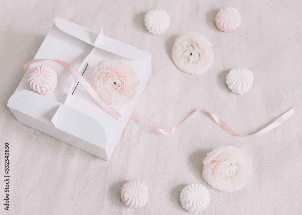 Gift or present box with pink ribbon and flowers on white background top view. Birthday or holiday background. pastel colors Gift or present box with pink ribbon and flowers on white background top view. Birthday or holiday background. pastel colors