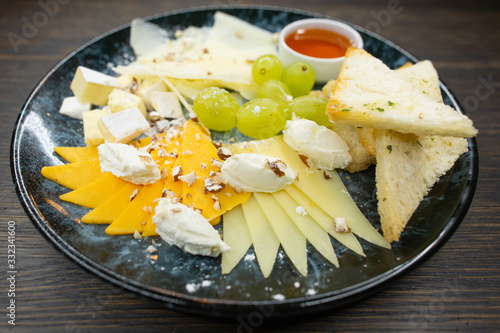 assorted cheese. thin sliced ​​cheese with grapes crispy croutons of white bread with honey and walnuts photo