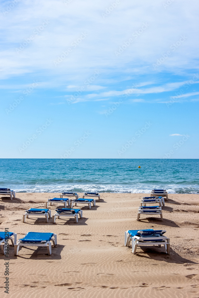 empty deck chairs by sea in spain