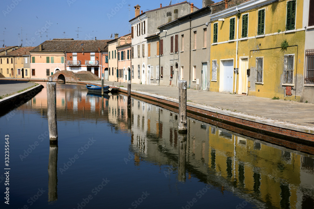 Comacchio (FE), Italy - April 30, 2017: Houses in Comacchio village reflecting in the water, Delta Regional Park, Emilia Romagna, Italy Comacchio (FE), Italy - April 30, 2017: Houses in Comacchio village reflecting in the water, Delta Regional Park, Emilia Romagna, Italy