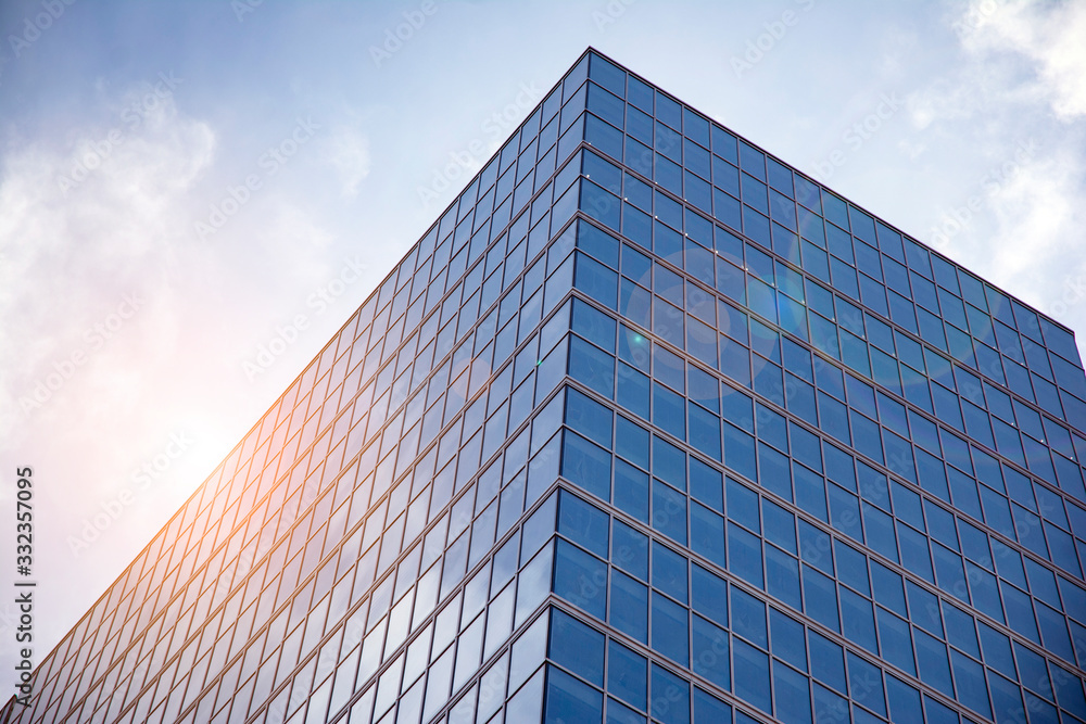 Office building glass facades on a bright sunny day with sunbeams in the blue sky. Abstract view of a skyscraper with sunlight Office building glass facades on a bright sunny day with sunbeams in the blue sky. Abstract view of a skyscraper with sunlight