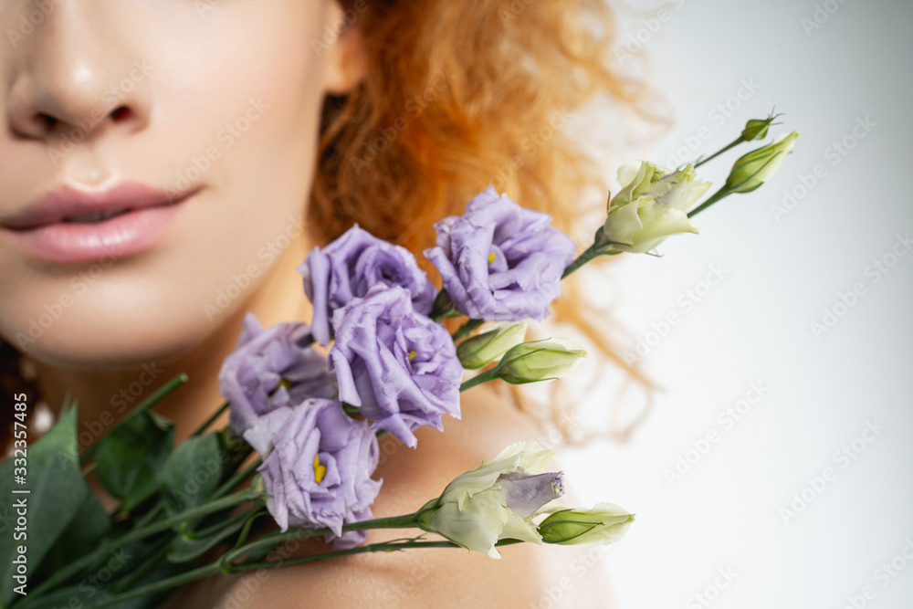 Naklejka premium Girl with lilac freesias on her shoulder