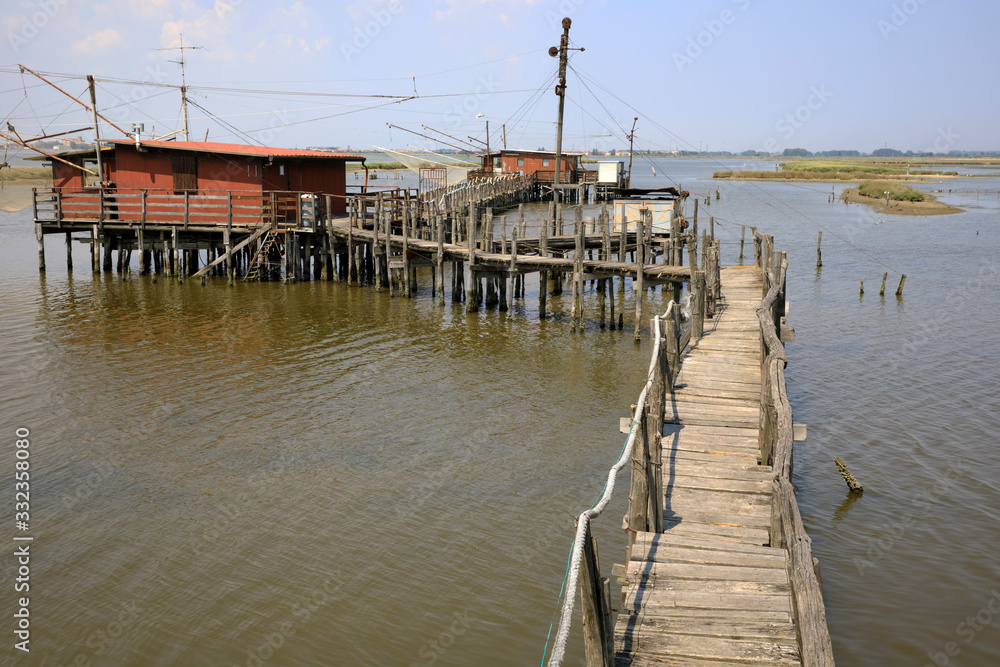 Po river (FE),  Italy - April 30, 2017: The pier with an old Fisherman's house on Po river, Delta Regional Park, Emilia Romagna, Italy
