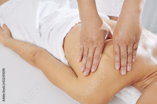 Close-up image of massage therapist applying sustained pressure using slow, deep strokes to target the inner layers of muscles