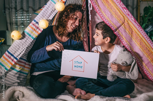 Mother and son showing a Sttay Home logo. Coronavirus concept photo