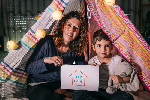 Mother and son showing a Sttay Home logo. Coronavirus concept photo