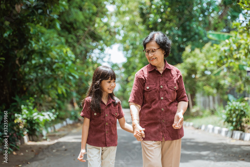 Asian grandmother with grandchildren walking together in the park enjoying a vacation