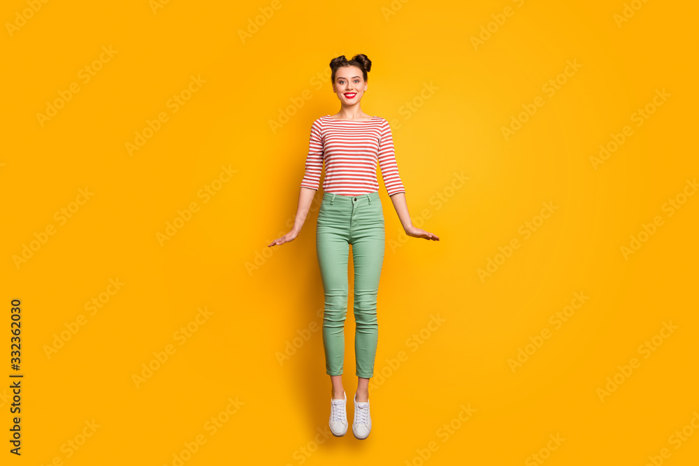 Full length photo of attractive pretty lady jumping high up rejoicing traveler abroad wear red white pullover shirt green pants footwear isolated bright yellow background Full length photo of attractive pretty lady jumping high up rejoicing traveler abroad wear red white pullover shirt green pants footwear isolated bright yellow background