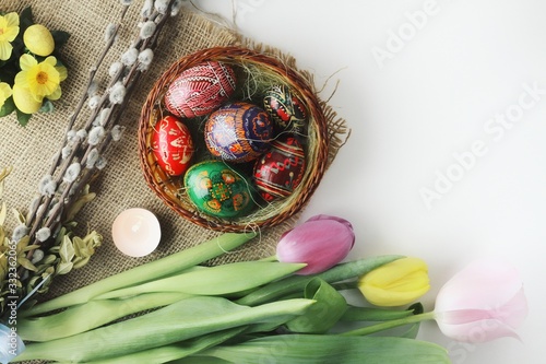 Obraz na płótnie Beautiful Eastern style flat lay with traditional painted eggs and tulips w salonie