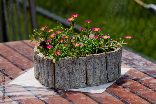 Flowers in a wooden pot on a table in a cafe.