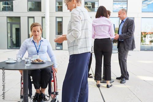 Disabled woman in a wheelchair takes coffee break