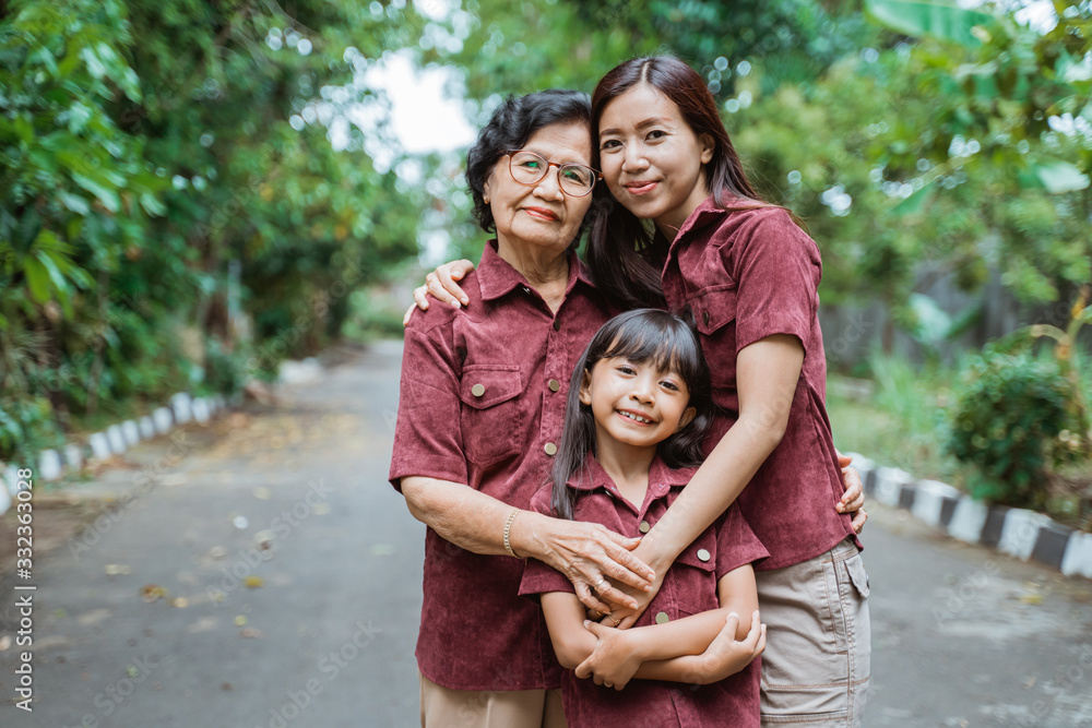 Fototapeta premium Asian families pose in the park, little girls, mothers and grandmothers pose while on vacation together