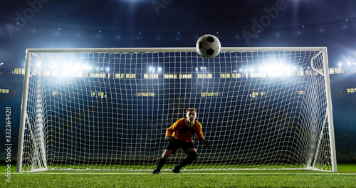 Goalkeeper is trying to save from a goal on an empty soccer stadium. No spectators on the tribunes. Stadium is made in 3d.