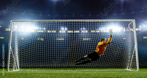 Goalkeeper is trying to save from a goal on an empty soccer stadium. No spectators on the tribunes. Stadium is made in 3d.