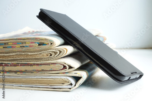 Newspapers amd Smartphone. News Pages with Headlines and Articles and Mobile Phone. Different Sources of Information - Internet or Papers. Concept for Communication