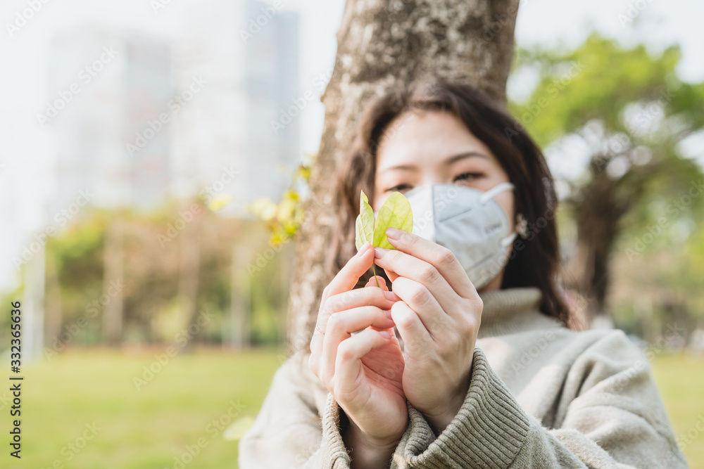 girl with a mask holding a green leaf in her hand girl with a mask holding a green leaf in her hand