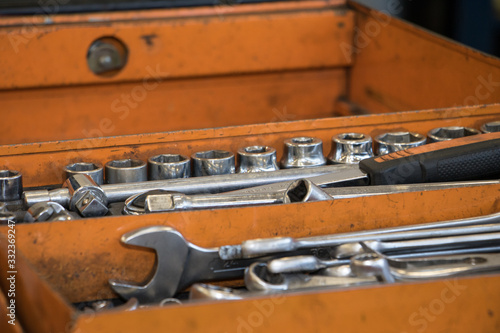 wrenches allen wrenches screwdrivers and stainless steel work tools of a mechanic in an orange toolbox