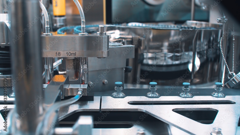 Automatic packaging machine for packaging ampoules with vaccine, injection and medical drugs.close up. coronavirus. Automatic packaging machine for packaging ampoules with vaccine, injection and medical drugs.close up. coronavirus.