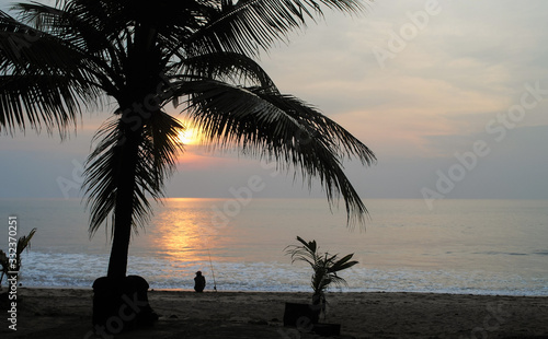 Men fishing on the beach at sunset