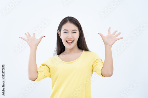 Asian young woman ware yellow t-shirt acting wonderful surprise with hand on mouth on white background photo