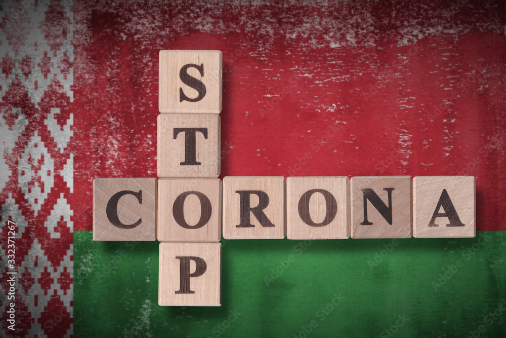 Obraz premium Flag of Belarus with wooden cubes spelling STOP CORONA on it. 2019 - 2020 Novel Coronavirus (2019-nCoV) concept art, for an outbreak occurs in Belarus.