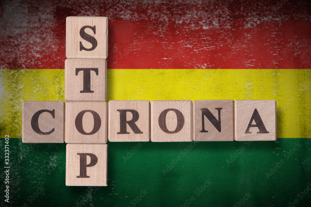 Obraz premium Flag of Bolivia with wooden cubes spelling STOP CORONA on it. 2019 - 2020 Novel Coronavirus (2019-nCoV) concept art, for an outbreak occurs in Bolivia.