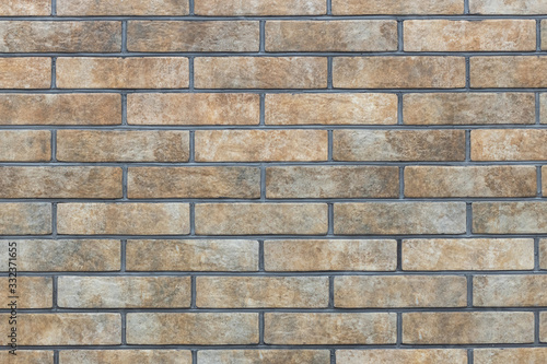 Wall of brown stone decorative facing brick texture, background