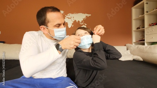 Father and son at home wearing masks hidding from a epidemy photo