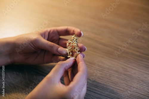  The bride holds gold jewelry in her hands. Wedding accessories © Yevhenii Kukulka