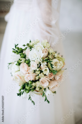 Wedding flowers. The bride holds a beautiful wedding bouquet of roses