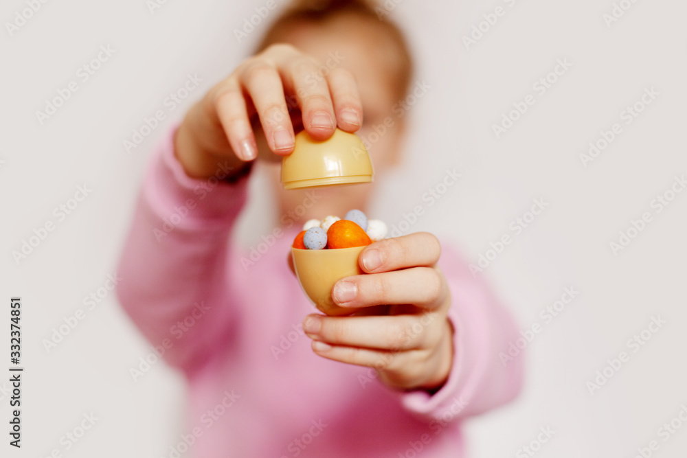 The girl is holding small chocolate eggs lying in one large egg. Concept of the Easter holiday The girl is holding small chocolate eggs lying in one large egg. Concept of the Easter holiday