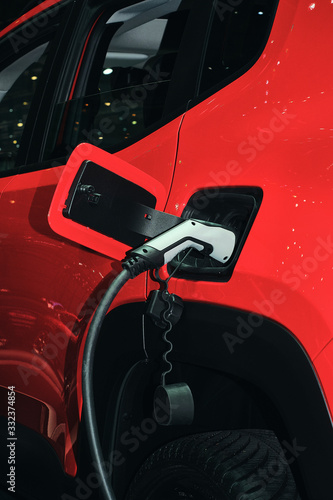 new red electric car charging at power station