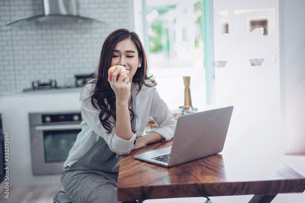 Portrait of beautiful young latin woman talking over the phone while cooking in kitchen Portrait of beautiful young latin woman talking over the phone while cooking in kitchen