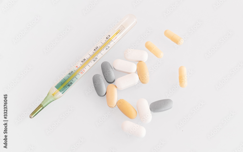 thermometer and pills isolated. treatment of the disease thermometer and pills isolated. treatment of the disease